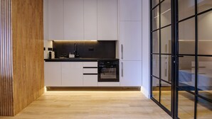 Una cocina moderna con armarios blancos, encimera negra y un horno.