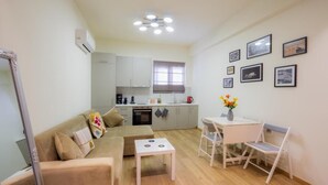A compact living space with a kitchenette, a sofa, a small dining table, and a chair. - Panathenaic Stadium Apartment by Greece Apartments (Athens)
