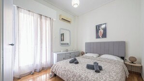 Ein Schlafzimmer mit einem Bett, Nachttischen, einem Spiegel und einem Poster an der Wand.