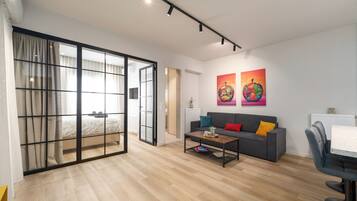 A modern living room with a sofa, coffee table, and artwork on the wall.