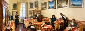 Enjoy a traditional dining experience with tables set for guests, surrounded by framed artwork and classic design elements.