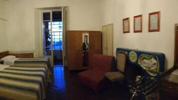 Ein Hotelzimmer mit zwei Betten, einem Schreibtisch, einem Stuhl, einem Fernseher und einem Fenster mit Blick.