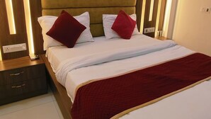 Une chambre à coucher moderne avec un grand lit, une tête de lit en bois et des tables de chevet.