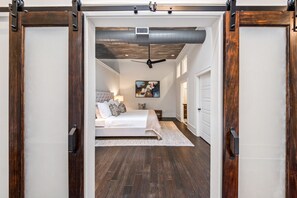 A bedroom with a bed, bedside table, and a painting on the wall. - Quiet Downtown Loft | Walk to Dining & Coffee (Macon)