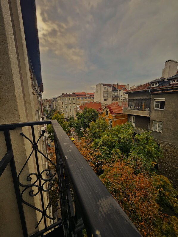 A balcony overlooking a cityscape with buildings and trees.