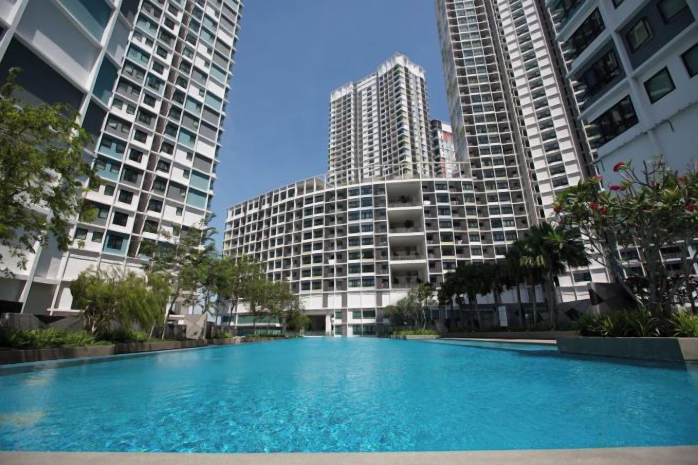 A swimming pool surrounded by high-rise buildings with balconies.