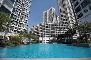 Une piscine entourée d’immeubles de grande hauteur dotés de balcons.