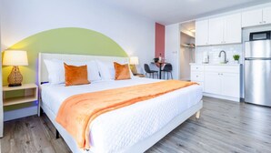 Une chambre d’hôtel équipée d’un lit, d’un bureau et d’une kitchenette.