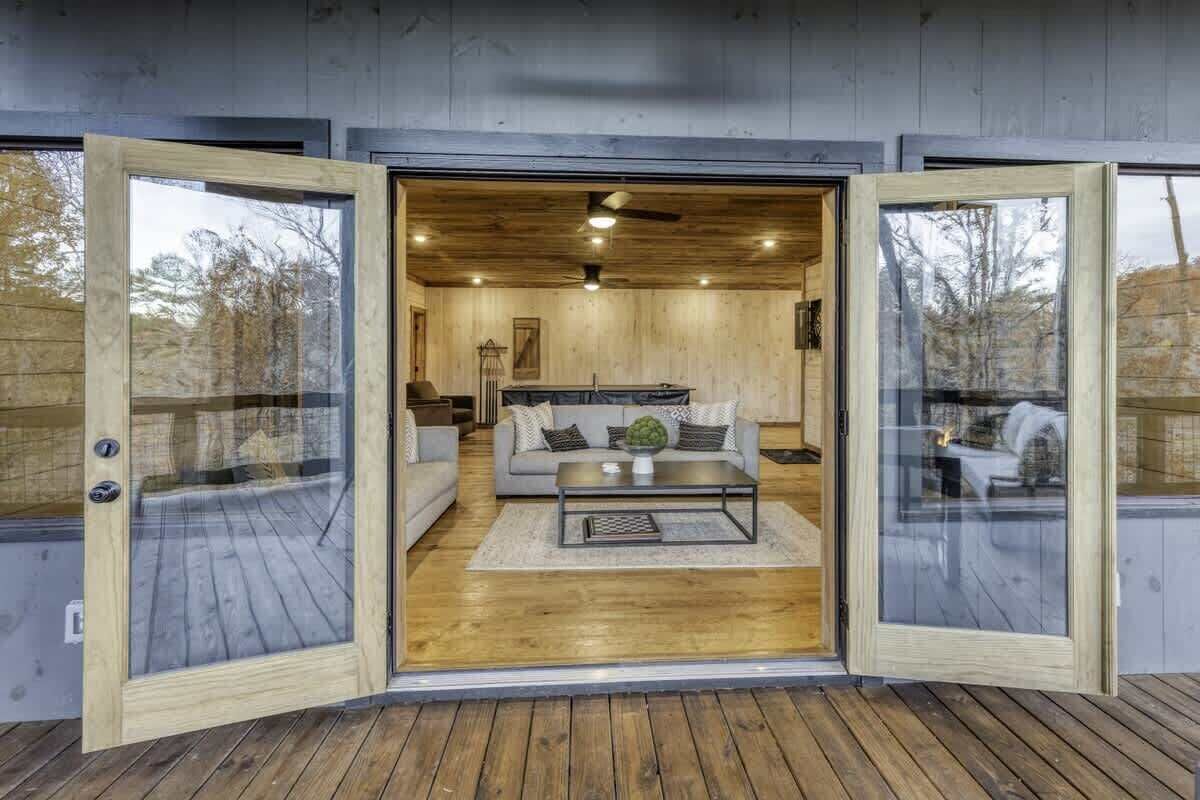 Un interior moderno con piso de madera, un sofá, una mesa de centro y un ventilador de techo.