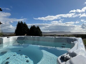 Ein Whirlpool mit freiem Blick auf das Meer und die entfernten Hügel.