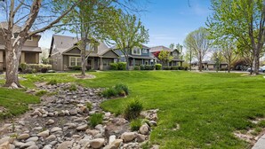 Un quartier résidentiel avec des maisons, une pelouse verdoyante et un sentier bordé de pierres.