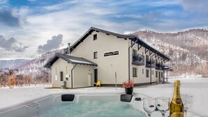 Edificio de spa con un jacuzzi y una botella de champán Zarea.