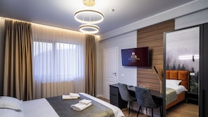 Una habitación de hotel moderna con cama, escritorio, silla y televisor.