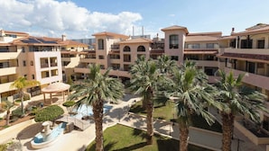A hotel courtyard with multiple floors, palm trees, and a central fountain.