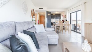 A modern living room with a grey sectional sofa, a wooden coffee table, and a white pineapple decoration. - Praia DA Rocha Ocean View by Homing (Portimão)