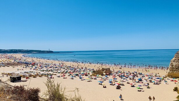 A crowded beach with numerous umbrellas and people enjoying the sunny weather. - Praia DA Rocha Ocean View by Homing (Portimão)