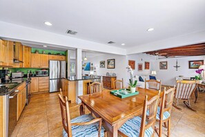 A spacious kitchen with wooden cabinets, a central island, and a dining area with a wooden table and chairs. - Casa Balsinde - Delight in a Private Pool in the Southern End of West Palm (West Palm Beach)