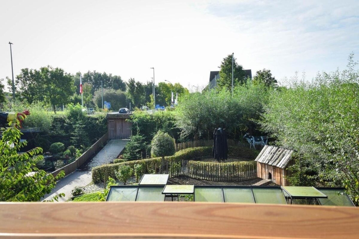 A garden with a wooden structure, a pathway, and a small building.