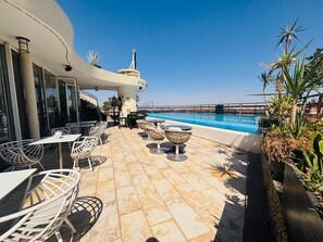 A rooftop pool area with outdoor seating and a clear view of the sea. - Hôtel La Renaissance Marrakech (Marrakech)