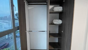 A modern closet with a sliding door, built-in shelves, and a hanging rod. - Outlanders House (Bogota)
