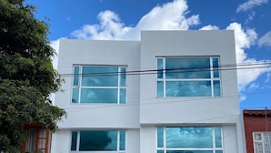 A modern two-story house with a garage, large windows, and a stone facade. - Outlanders House (Bogota)