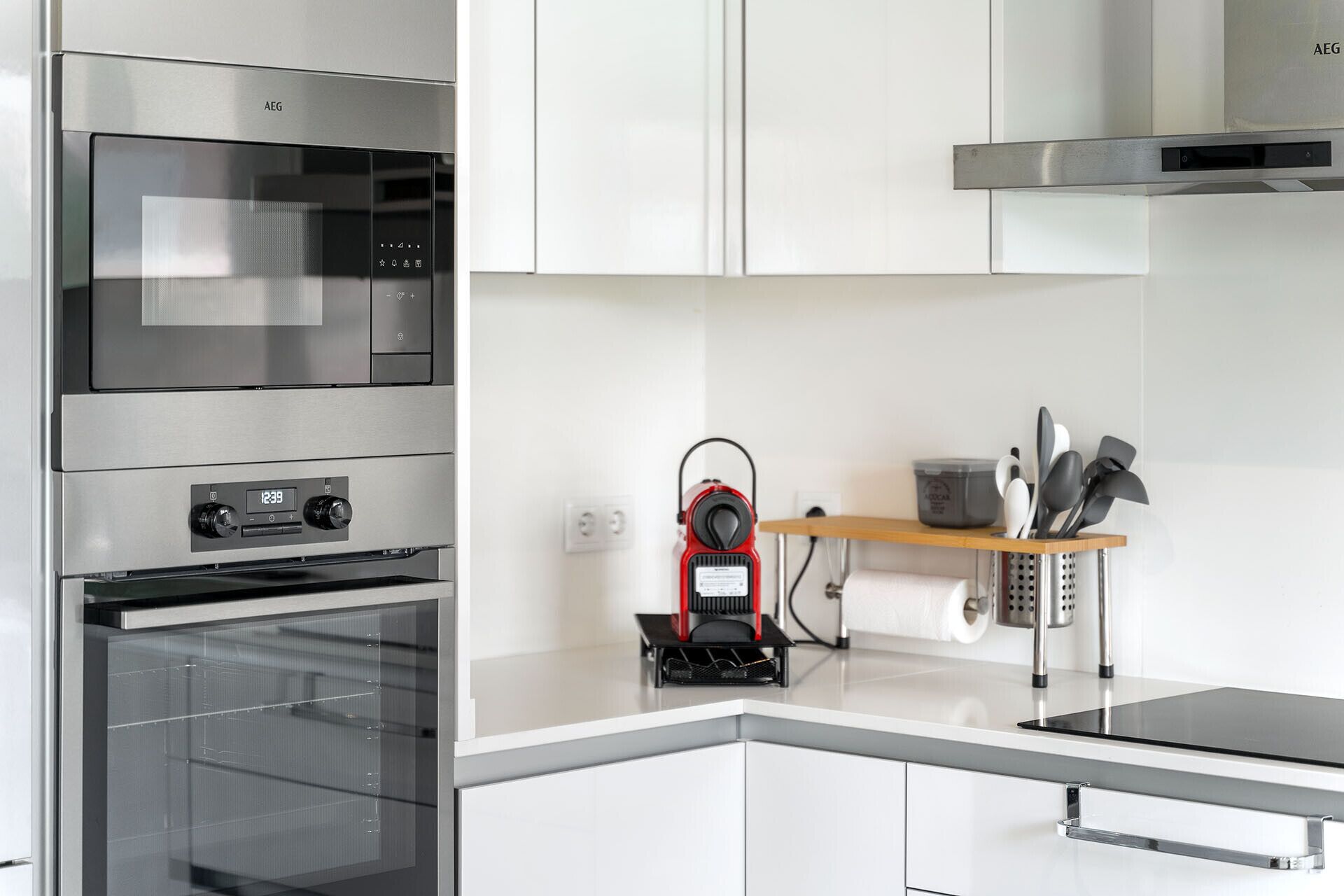 A modern kitchen with stainless steel appliances, a built-in oven, and a compact microwave.