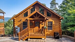 A log cabin with a wooden porch, a staircase, and a sign reading "1719 Lovers Paradise".