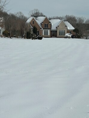 A two-story house with a snow-covered roof and a driveway. - Lake Anna Waterfront, Private Pool&Spa, Game Room, Pickle Ball, Tiki, Fire pit (Orange)
