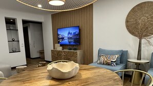Ett modernt matområde med ett träbord, guldiga stolar och en unik hängande lampa.
