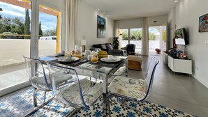 A modern living room with a glass dining table, clear chairs, and a sofa. - Vilamoura Club Villa 3 by Homing (Loulé)