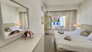 Una camera d'albergo con un letto, una scrivania, uno specchio e una finestra vista esterna.