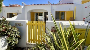 Un edificio bianco con persiane gialle e un cartello con il numero 42.