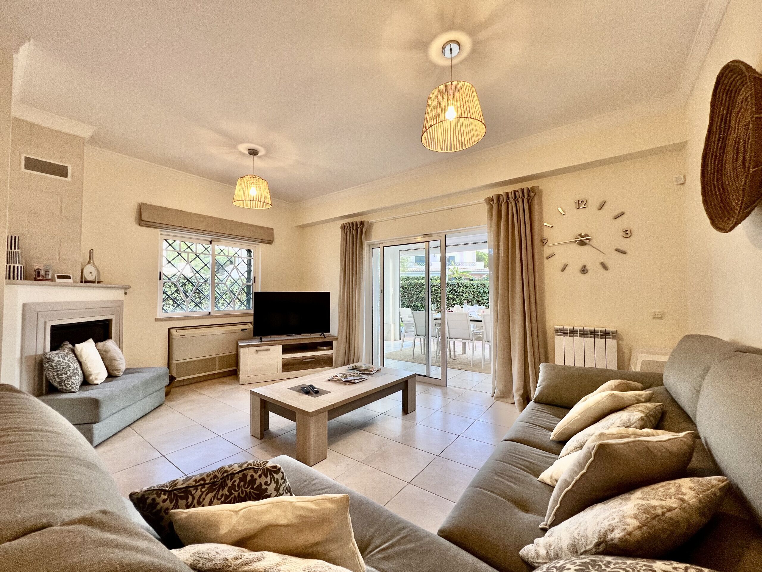 A living room with a sofa, a coffee table, a flat-screen TV, and a fireplace.