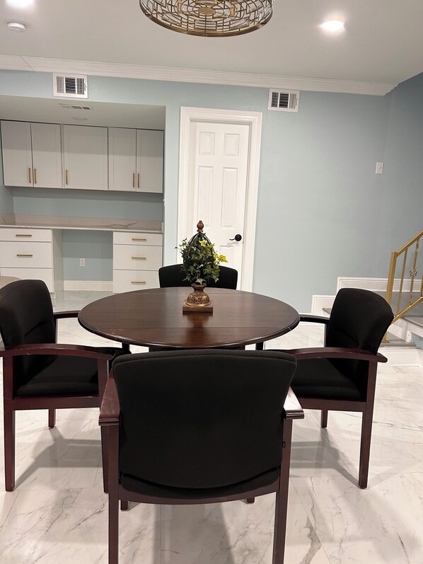 A dining area with a round table, four chairs, a decorative plant, and a white door in the background. - 4-bedroom house in fabulous Metairie with AC, WiFi. Enjoy your stay (Metairie)