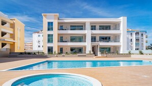 A modern multi-story hotel with a swimming pool and a hot tub. - Lagos Marina View 2 With Pool by Homing (Lagos)