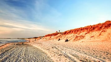 Una playa con dunas de arena y cielo despejado.