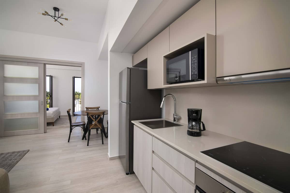 A modern kitchen with a built-in microwave, a coffee maker, and a sleek countertop.