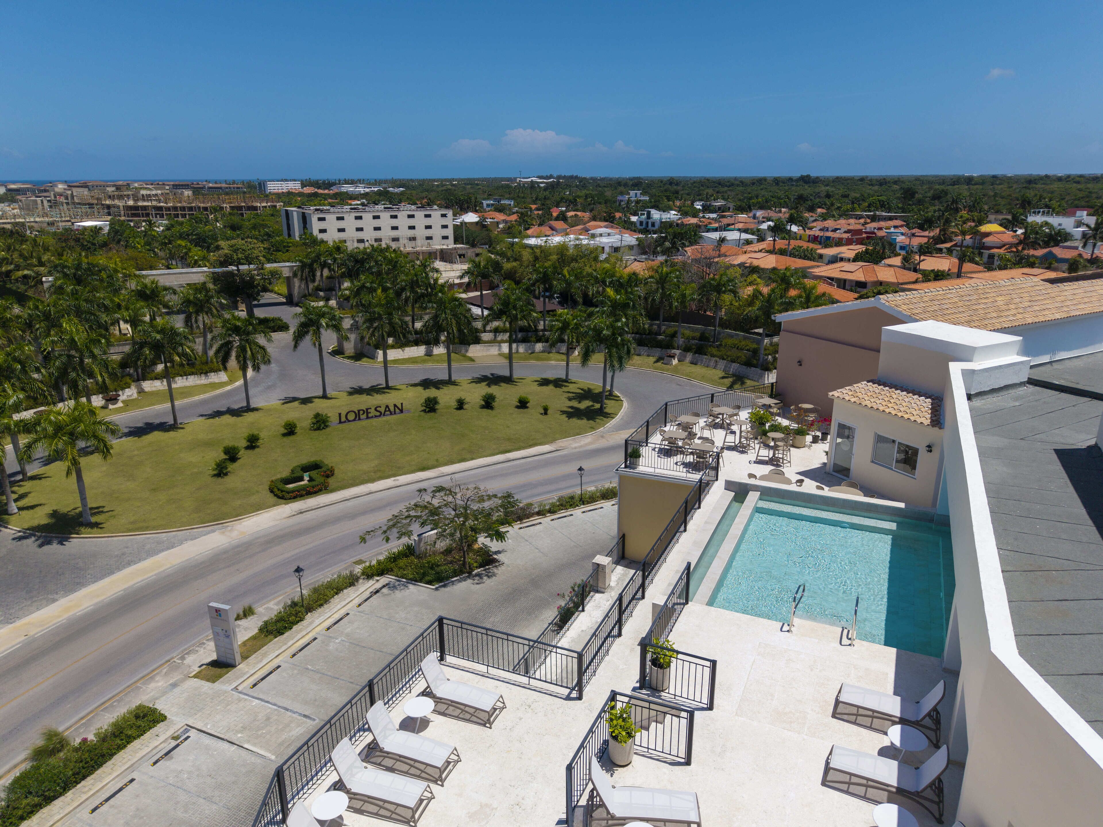 A rooftop pool area with lounge chairs and a swimming pool.