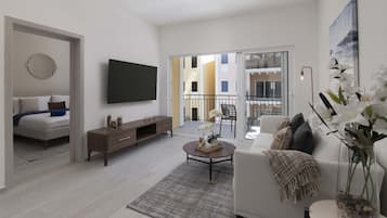 A modern living room with a sofa, coffee table, and a flat-screen TV mounted on the wall.