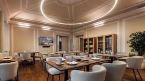 A dining area with round tables, chairs, and a ceiling with a circular light fixture. - CICIOSO Boutique Hotel (Évora)