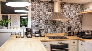 A kitchen with a wooden countertop, a coffee maker, a toaster, and a stove.