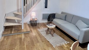 A modern living room with a staircase, a grey sofa, and a wooden floor. - Jeanne's apartment. 500 from the castle, in a quiet, green setting (Chinon)