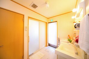 A hotel bathroom with a sink, mirror, and towel rack. - Awaji Central Inn Kuruma713 (Awaji)
