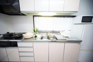 Cocina compacta con microondas, estufa y lavaplatos.