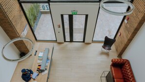 Een receptiegedeelte met een bureau, een bank en een deur met een vluchtwijzer.