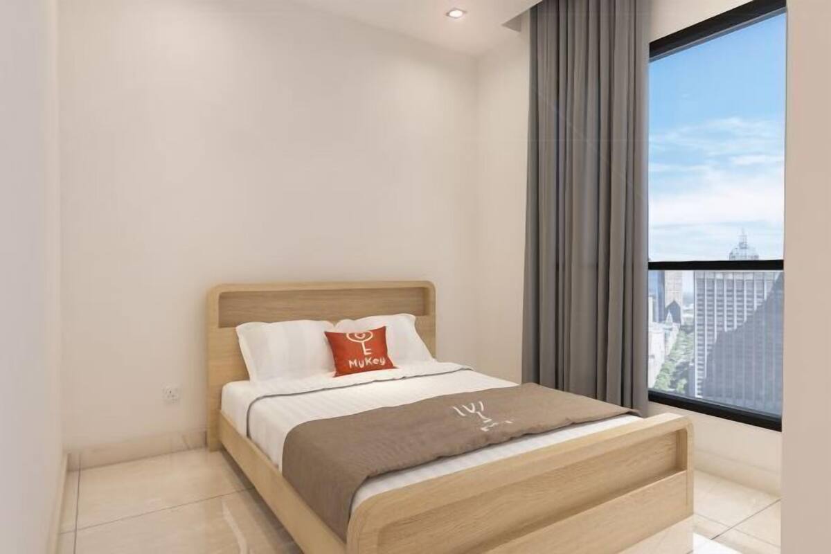 Ett modernt hotellrum med ett stort fönster, en säng med ett huvudgavel av trä och utsikt över staden.