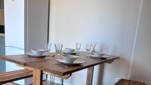 A dining area with a wooden table and benches, a white refrigerator, and a simple, clean design. - CHALET WITH EXCEPTIONAL SEA VIEW (Saint-Raphaël)