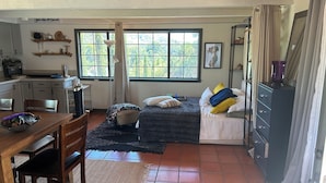 A compact room with a bed, a desk, and a dining area. - Charming, quiet cottage in brilliant Fallbrook with AC, WiFi, private, Smart TV. (Fallbrook)