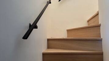 Un escalier avec des marches en bois et des rampes noires.