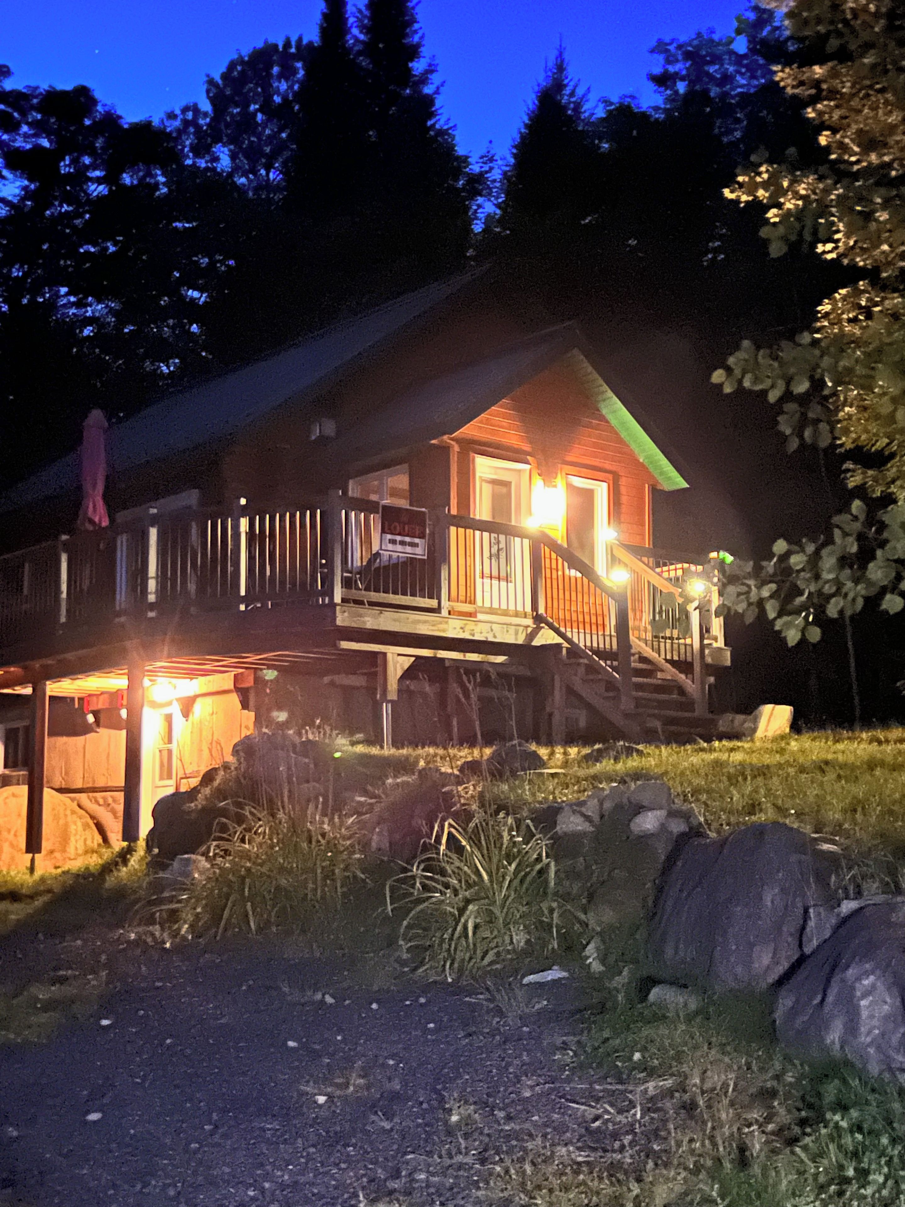 A wooden cabin with a porch and a staircase leading to the entrance.